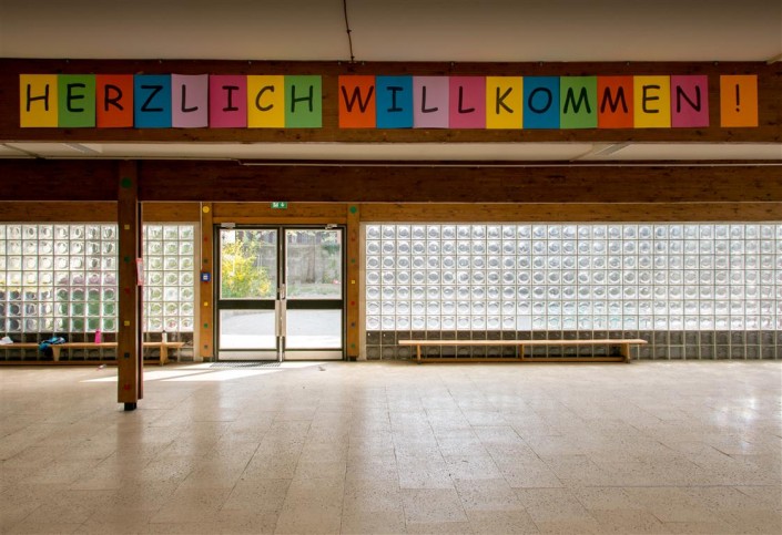 Bild: Aula mit Schriftzug Herzlich Willkommen